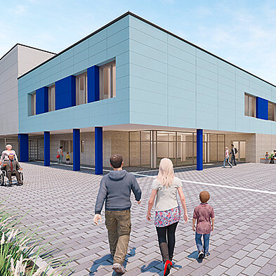 Ein modernes Gebäude mit hellblauer Fassade und blauen Fensterrahmen. Vor dem Gebäude gehen eine Familie und eine Person im Rollstuhl auf einem gepflasterten Weg. Die Umgebung ist freundlich und einladend gestaltet.