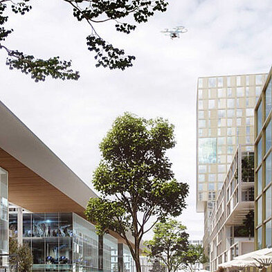 Moderne städtische Architektur mit mehreren Gebäuden, Bäumen und Menschen auf einem Boulevard. Ein Drohne schwebt über der Szene. Die Umgebung wirkt einladend und modern, mit Glaselementen und viel Grün.