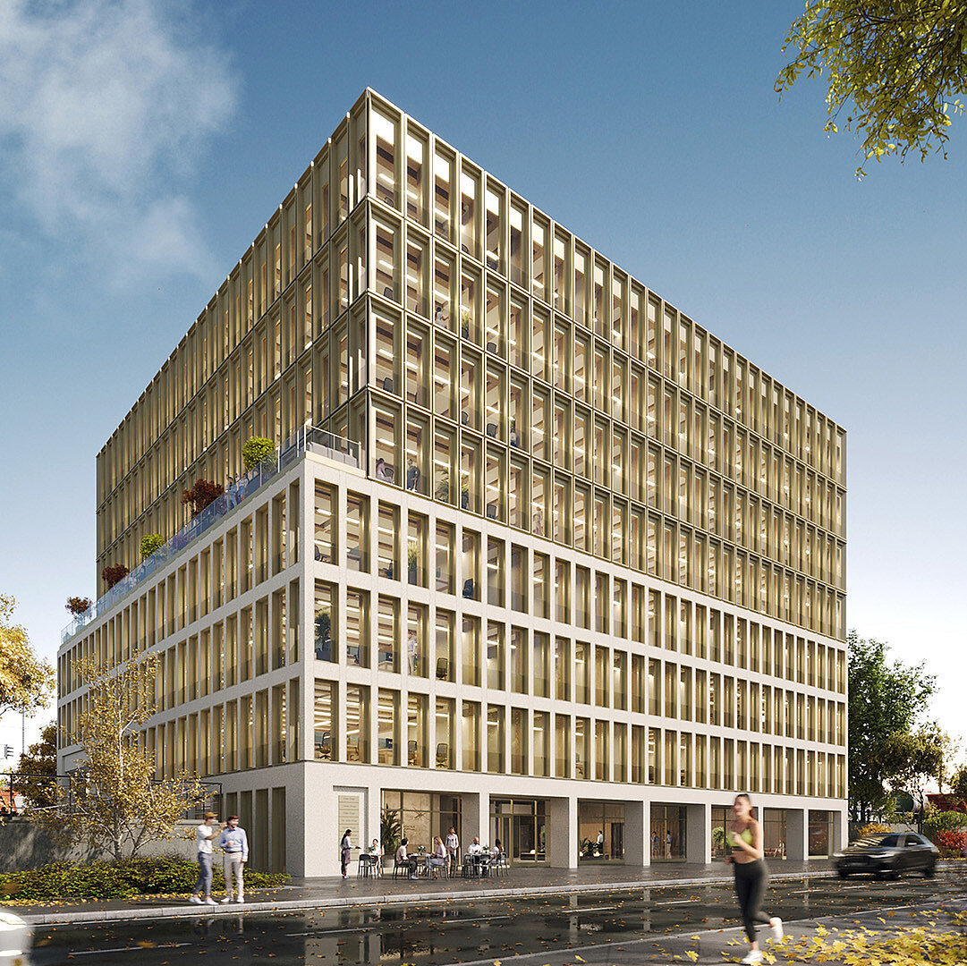Moderne Gebäudefront mit großen Fenstern und einem rechteckigen Design. Das Gebäude hat mehrere Etagen und ist von Bäumen umgeben. Zu sehen sind Fußgänger und Fahrzeuge auf der Straße. Der Himmel ist blau mit einigen Wolken.