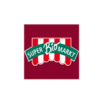 Logo eines Bio-Marktes mit rotem Hintergrund. Das Logo zeigt rote und weiße Streifen sowie den Schriftzug „SUPER BIO MARKT“ in grüner Schrift auf einem Banner.
